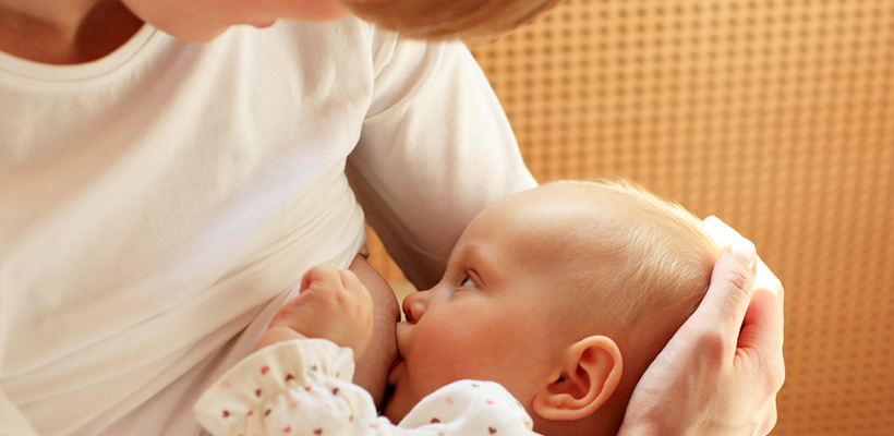 Ein baby stillt von seine Mutter. 