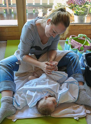 eine Mutter massiert den Füß von ihr Baby. 