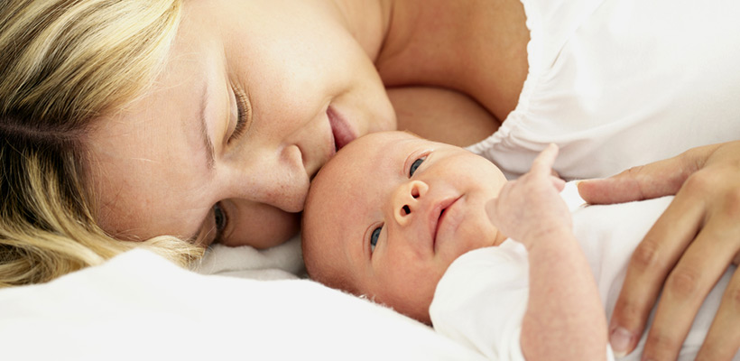 Eine Mutter streichelt ihr neues Baby. 