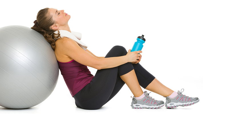 Nach eine Übung mit dem Fitness-Ball, enspannt sich eine Frau. 